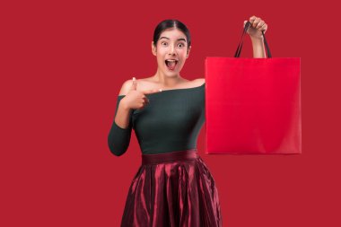 mutlu genç Sevimli kadın kırmızı arka plan üzerinde alışveriş torbaları ile poz portresi.