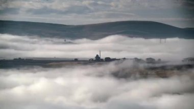 Sinema 8K 7680x4320 Zaman atlaması. Bulutların üzerindeki cami. Sisin üstündeki minare camii. Mistik ibadet yeri, köy evlerinin yakınındaki tapınak. Tanrı 'nın Evi. Gizemli ruhani ebediyet..