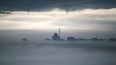Sinema 8K 7680x4320 Zaman atlaması. Bulutların üzerindeki cami. Sisin üstündeki minare camii. Mistik ibadet yeri, köy evlerinin yakınındaki tapınak. Tanrı 'nın Evi. Gizemli ruhani ebediyet..