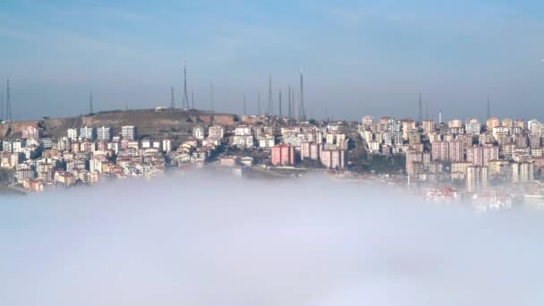 都市の丘の上のアンテナを送信します 雲の上の斜面の家町のアパートの建物をカバー霧がアパートを落下しています — ストック動画