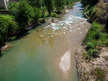 Dağdaki taşların arasından akan suyu oluşturan kıllı bir manzara.