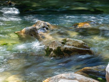 Dağdaki taşların arasından akan suyu oluşturan kıllı bir manzara.