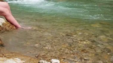 Adam bir dağ nehrinde sıcak bir içki içiyor..