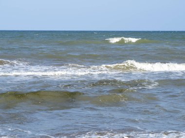 Deniz dalgaları ve bulutlu mavi gökyüzü