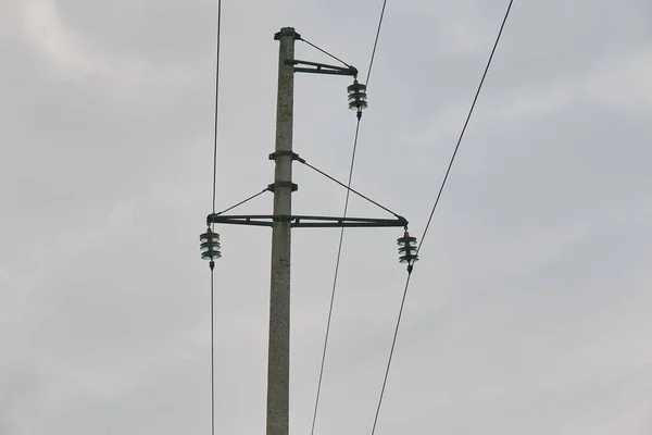 electricity transmission pole silhouetted against blue sky at dusk