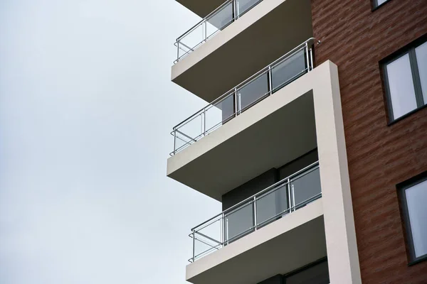 modern beautiful apartment house in european city. with balconies with dark brown facade. polished chrome steel elements