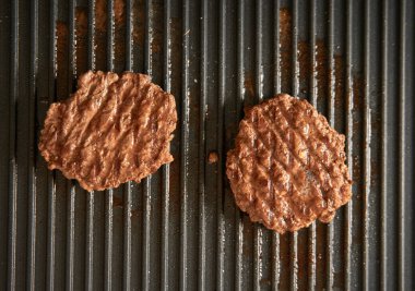 Köfteli köfteler tavada pişiyor. Koyu arkaplan Izgarası