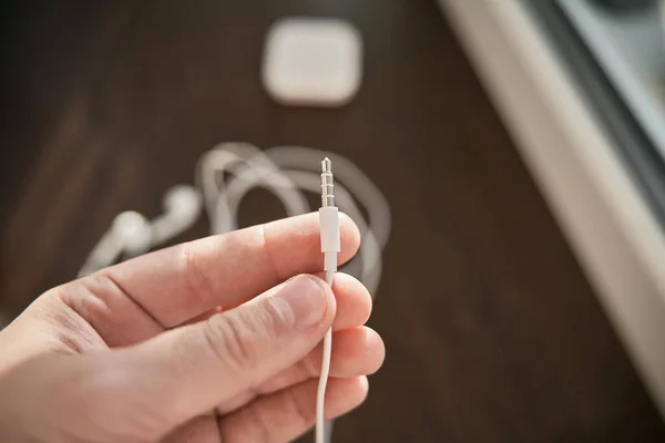 Man Hand Holds 5Mm Mini Jack Connector White Headphone Jack — Stock Photo, Image