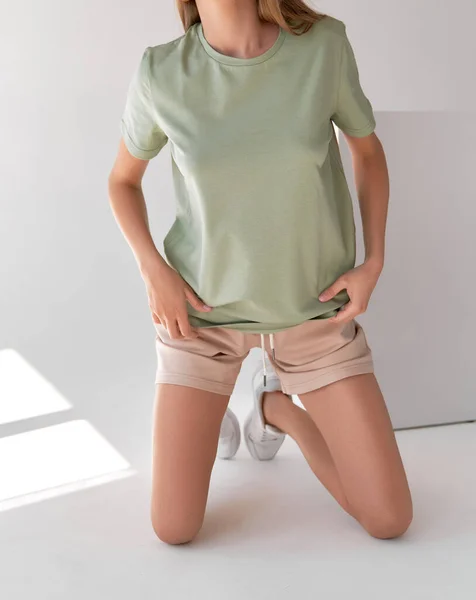 woman wears green oversize t shirt with copy space. indoor studio clothes mockup