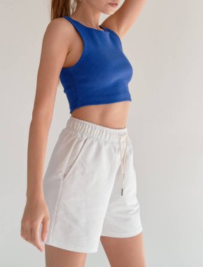 Kadınlar mavi bluz ve beyaz şort giyer. İç mekan hayat tarzı genç kız.