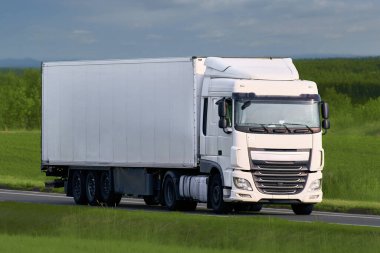 Manzaralı otobanda seyahat eden şirket beyaz kamyonu.