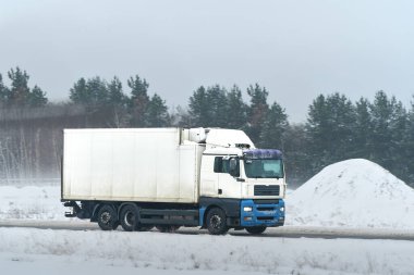 Taşıma kamyonu kırsal yolda hareket halinde.