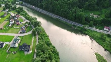 Road between lush forest and river