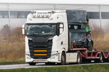 Yıkılmış araçlar düz bir çekiciyle taşınıyor..