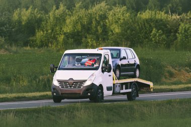 Flatbed çekicisi taşraya araba taşıyor.