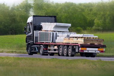 Kargo kamyonu, taşra yolunda malzeme taşıyor.