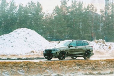 Karlı kırsallarda gezinen bir SUV.