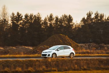 Açık kırsal yolda araba hareket halinde.