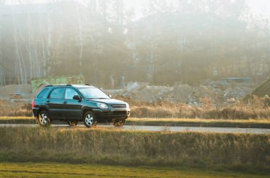 Güneş ışığında kırsal bir yolda SUV