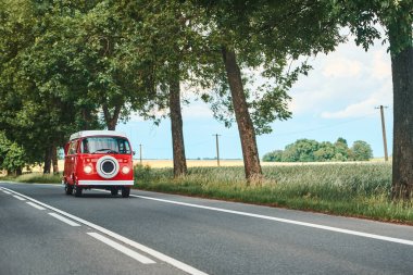 Red retro camper van on country road