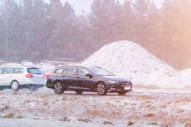 Karlı orman yolunda araç sürüyor.