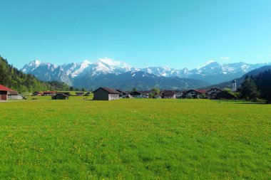 Manzaralı kırsal evlerin arkasındaki karlı dağlar