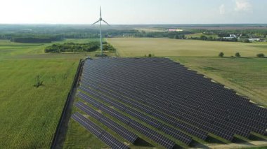 Solar farm under construction with wind turbine