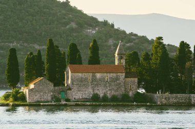 Göl adasındaki manastırda selvi ağaçları var.