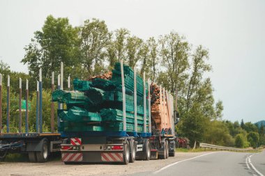 trucks carrying timber and planks on countryside