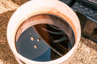 Kirli kovada eski motor yağı atığı