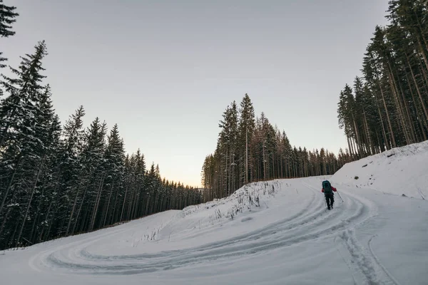 Um homem cavalgando esquis em uma encosta coberta de neve viajar — Fotografia de Stock