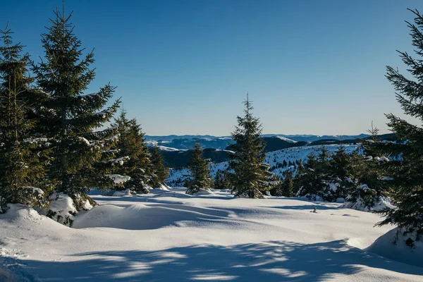 Um homem montado em cima de uma encosta coberta de neve — Fotografia de Stock