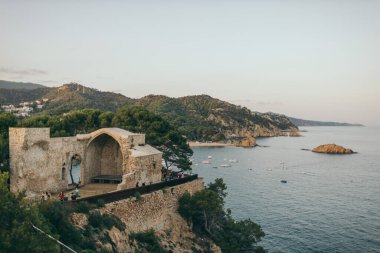 Arka planda dağ olan bir su kütlesinin üzerindeki köprü.
