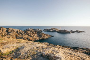 Bir su kütlesinin yanında kayalık bir plaj.