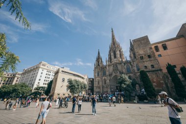 Bir grup insan binanın önünde yürüyor.