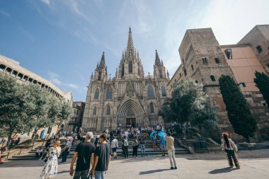 Bir grup insan binanın önünde yürüyor.