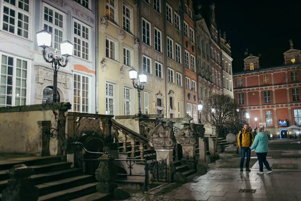 Eine Gruppe von Menschen läuft eine Straße neben einem Gebäude entlang — Stockfoto