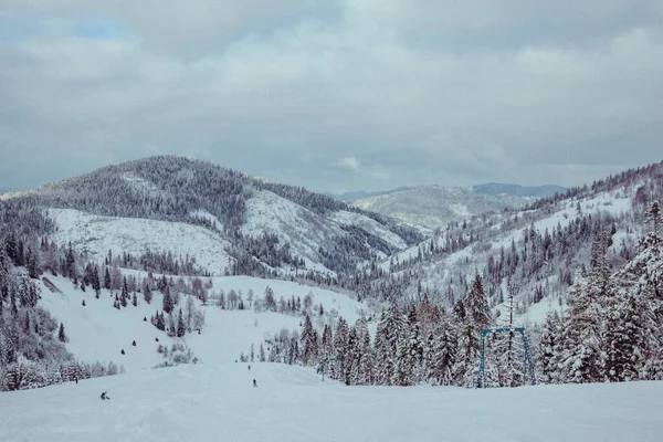 Um homem em pé no topo de uma montanha coberta de neve — Fotografia de Stock