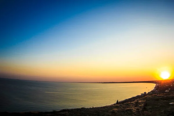 Una puesta de sol sobre un cuerpo de agua — Foto de Stock