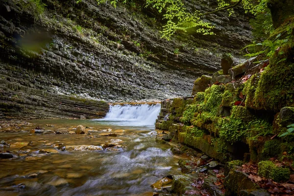 Uma grande cachoeira sobre um penhasco rochoso — Fotografia de Stock