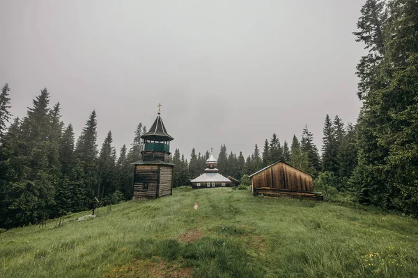 Egy épület füves mezővel, fák a háttérben. — Stock Fotó