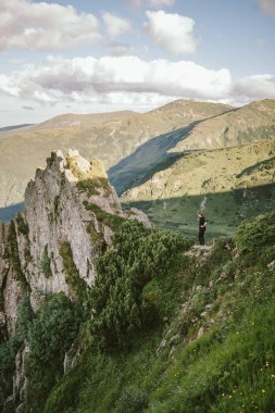 Kayalık bir tepede duran bir grup insan.