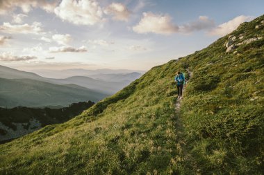 Bir grup insan yemyeşil bir yamaçta dikiliyor.