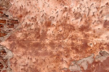 Hasarlı alçıyla eski püskü bina cephesi. Eski tuğla duvar dokusu