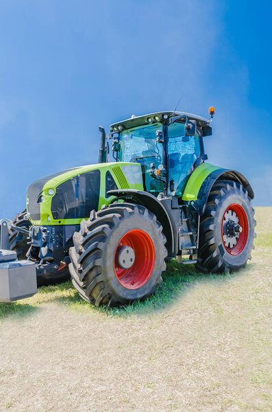 современный трактор для сельского хозяйства на ферме с мощным двигателем, флагман современной аграрной промышленности
