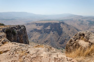 Güneşli bir günde dağların manzarası insanların dağ yerleşiminden ve gölden manzaralı.