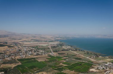 Güneşli bir günde dağların manzarası insanların dağ yerleşiminden ve gölden manzaralı.