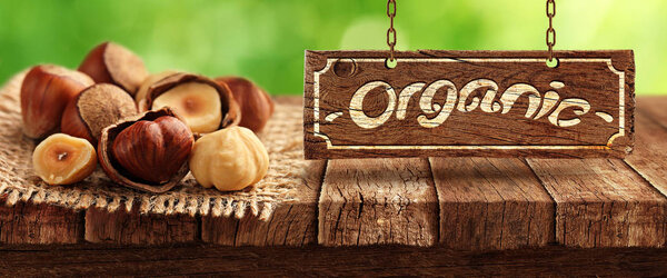 Nuts on wooden table and nature in background