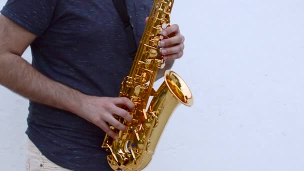 Junger Musiker Spielt Saxofon Einem Außenplatz Mit Weißer Wand Hintergrund — Stockvideo