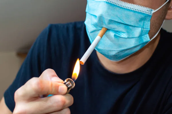 Jovem Com Máscara Acendendo Cigarro Conceito Engraçado Coronavirus — Fotografia de Stock